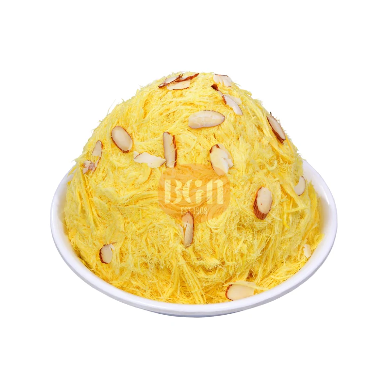 A white bowl filled with a golden-yellow Mango Soan Cake, topped with sliced almonds, showcasing its fluffy, shredded texture and appetizing appearance